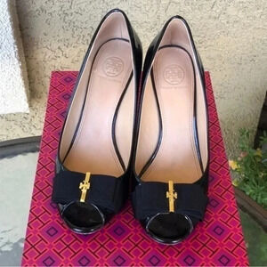 Tory Burch Black patent leather with bow and gold TB emblem
Leather sole